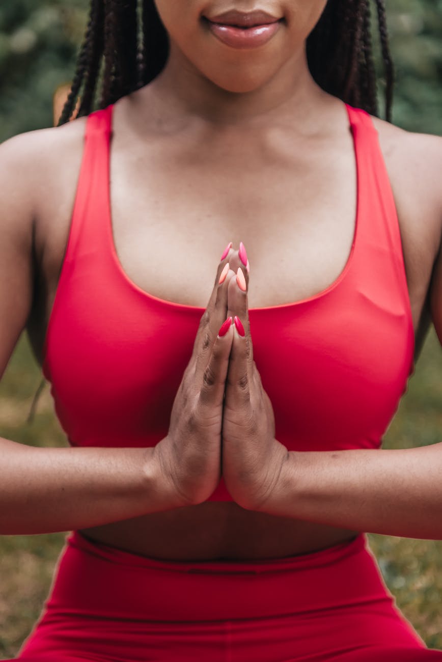 close up photo of woman in red activewear meditating